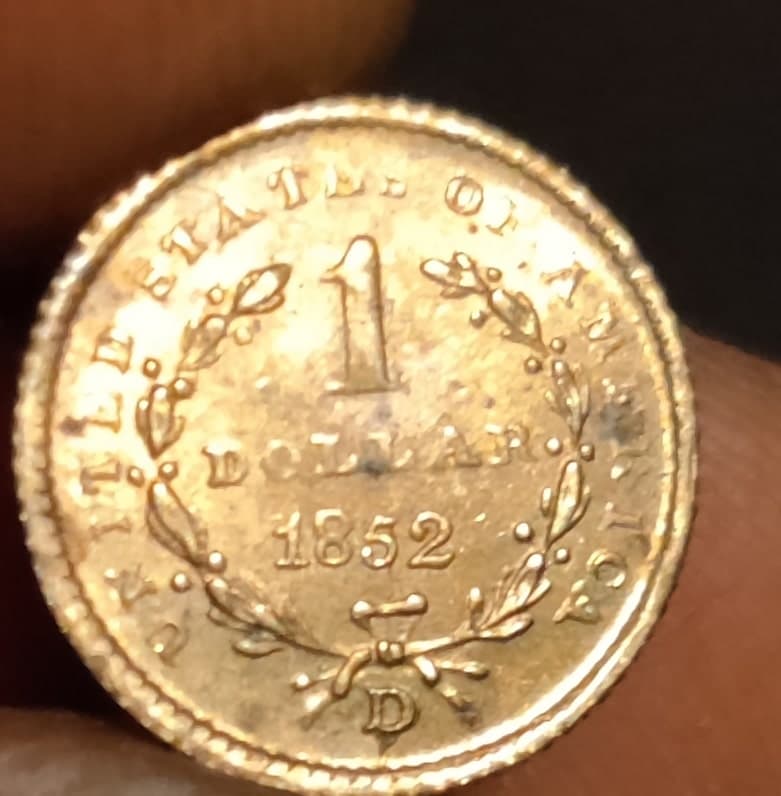 Taxatie van de waarde van een Amerikaanse dollar munt uit 1852 in uitstekende staat