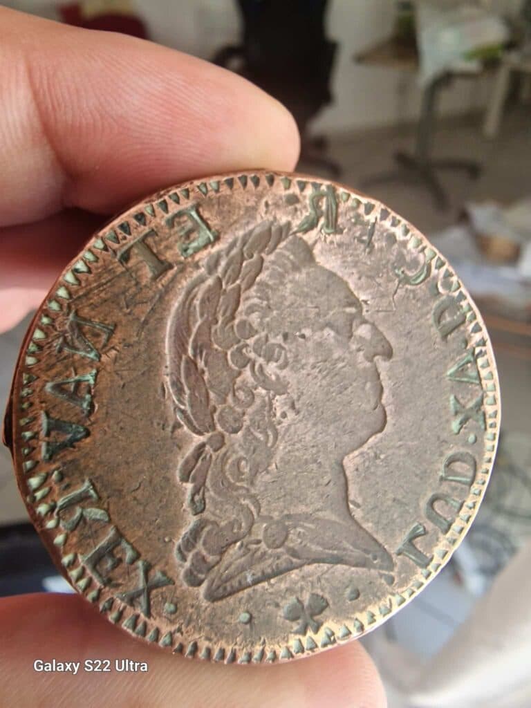 Taxatie van een bronzen munt geslagen in de tijd van Lodewijk XV met een hoogte van 4,2 cm en een breedte van 2,4 cm Taxatie van een bronzen munt geslagen in de tijd van Lodewijk XV met een hoogte van 4,2 cm en een breedte van 2,4 cm