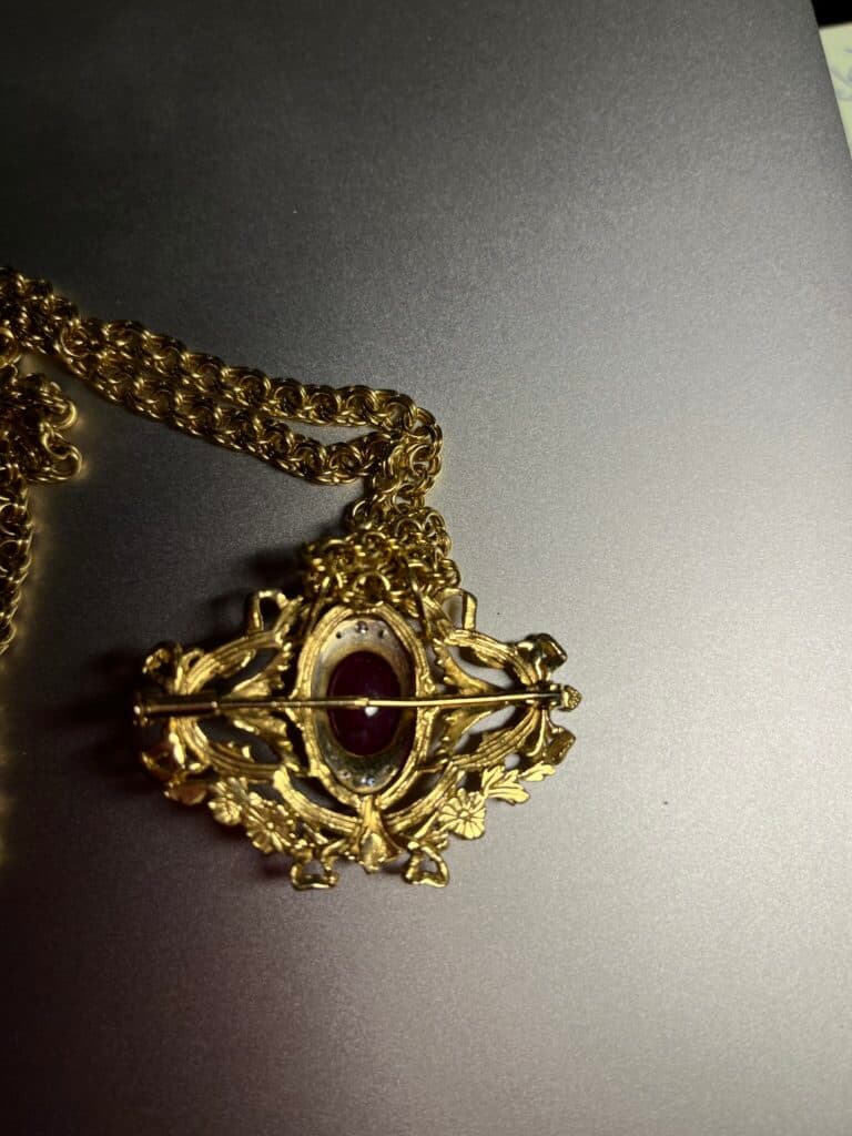 Taxatie van een gouden hanger versierd met robijnen, vergezeld van een gouden ketting, waardevol familie-erfstuk uit 1990 Taxatie van een gouden hanger versierd met robijnen, vergezeld van een gouden ketting, waardevol familie-erfstuk uit 1990