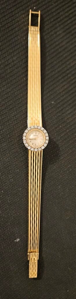 Taxatie van de waarde van een elegante Omega dameshorloge in goud, versierd met 20 ronde diamanten Taxatie van de waarde van een elegante Omega dameshorloge in goud, versierd met 20 ronde diamanten