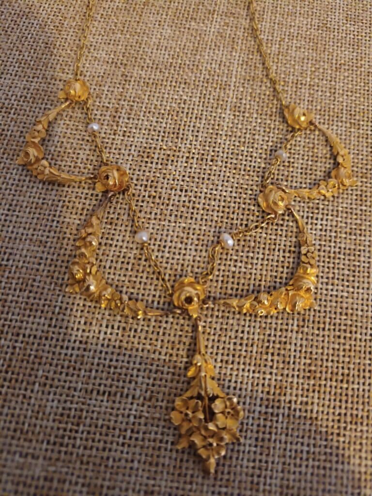 Taxatie van een uniek sieraad: een oude ketting van verguld metaal versierd met bloemen en parels uit de tijd van mijn overgrootmoeder. Taxatie van een uniek sieraad: een oude ketting van verguld metaal versierd met bloemen en parels uit de tijd van mijn overgrootmoeder.