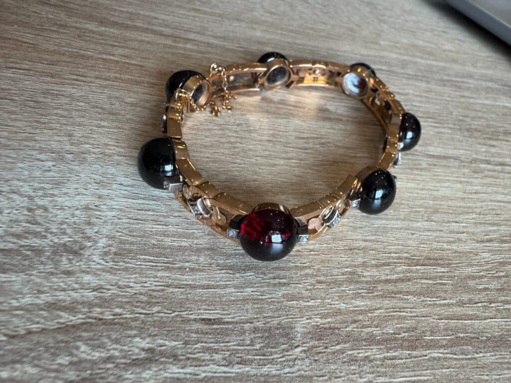 Prachtige vintage armband van goud versierd met donkerrode en zwarte stenen