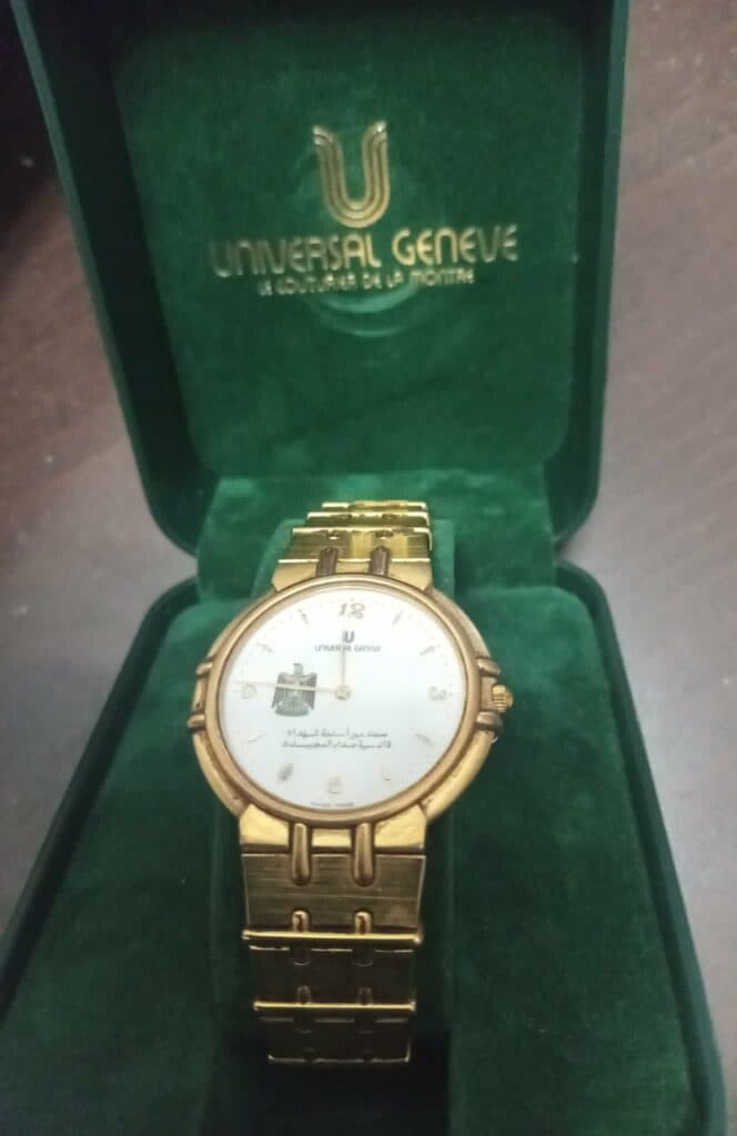 Taxatie van een waardevol Universal Geneve horloge in verguld staal, een speciale bestelling voor het Iraakse presidentschap van 1990-1991 met de originele doos.